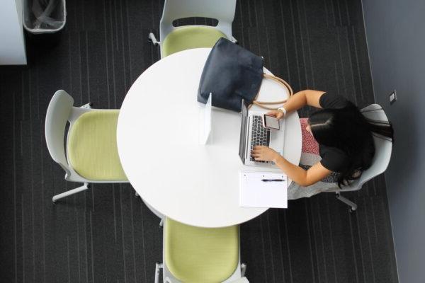 a person sitting at a table with a laptop